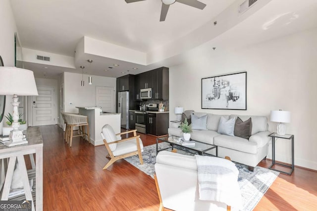 living room with ceiling fan and dark hardwood / wood-style flooring