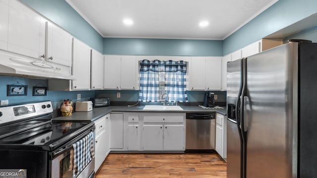 kitchen with white cabinetry, sink, ornamental molding, stainless steel appliances, and dark wood-type flooring