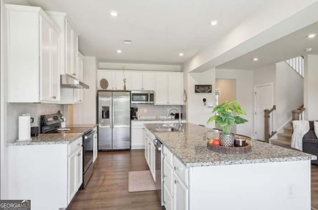 kitchen with white cabinetry, appliances with stainless steel finishes, and a kitchen island with sink