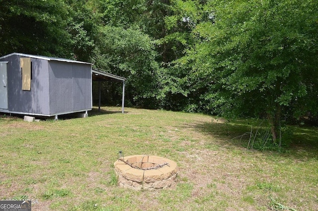 view of yard with a storage unit and a fire pit