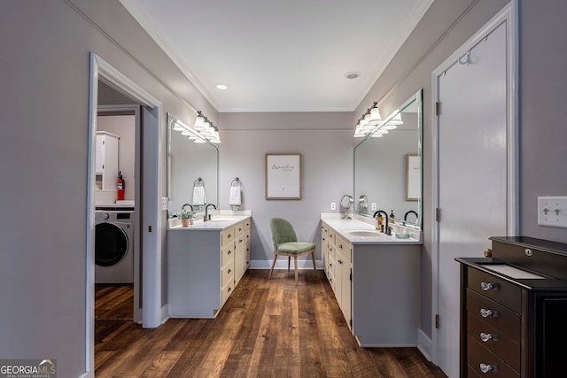 bathroom with ornamental molding, washer / dryer, hardwood / wood-style floors, and vanity