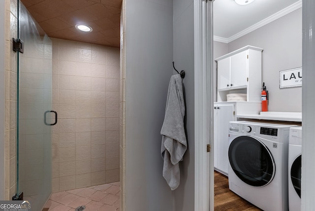 clothes washing area with ornamental molding, dark hardwood / wood-style floors, and washing machine and dryer