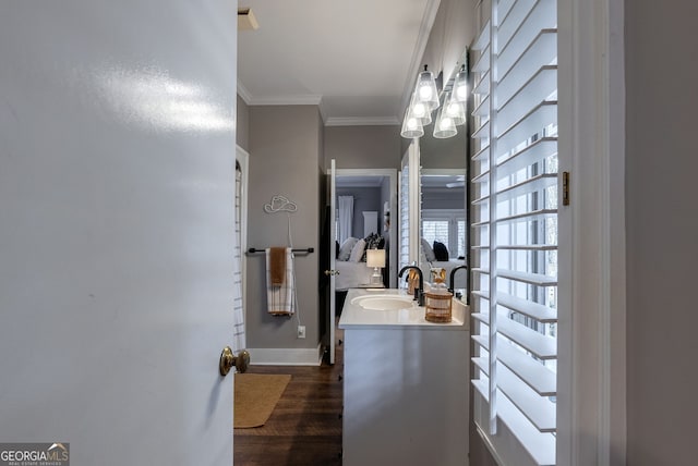 bathroom featuring hardwood / wood-style flooring, ornamental molding, and vanity