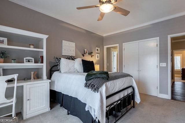 bedroom featuring crown molding, ceiling fan, light carpet, and a closet