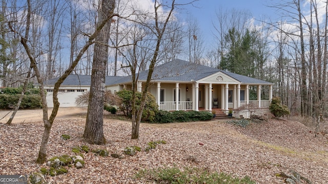 neoclassical home featuring a garage and covered porch