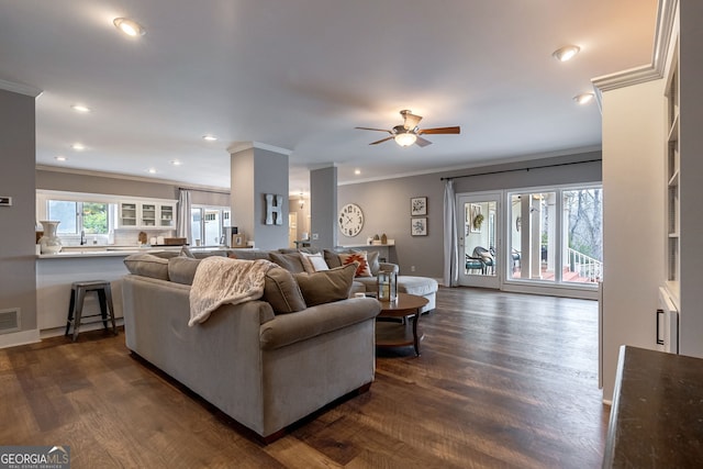 living room featuring dark wood-type flooring, ceiling fan, and ornamental molding