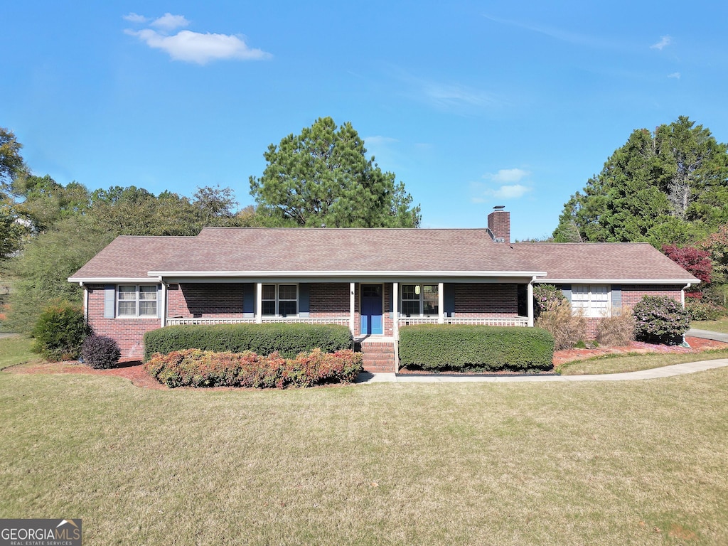 ranch-style home featuring a porch and a front yard