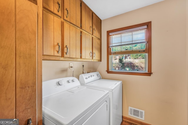 clothes washing area with independent washer and dryer and cabinets