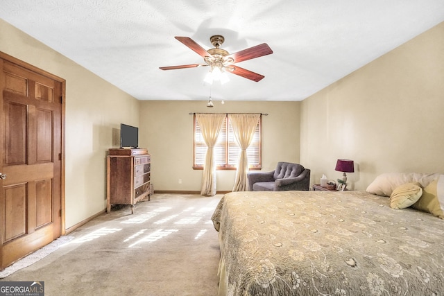 bedroom with light carpet, ceiling fan, and a textured ceiling