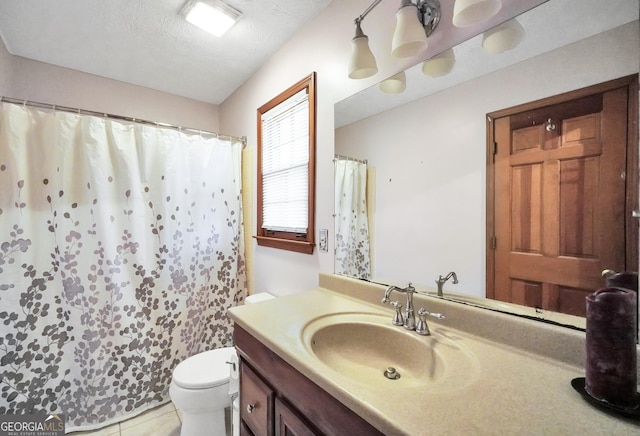 bathroom featuring tile patterned flooring, vanity, a textured ceiling, and toilet