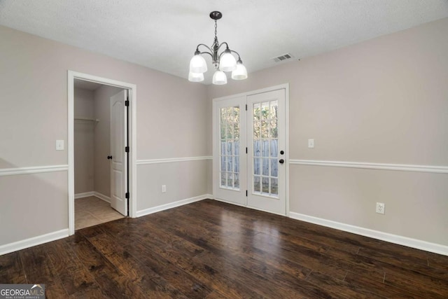 unfurnished dining area with hardwood / wood-style floors and a chandelier