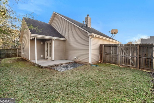 rear view of house with a patio and a lawn