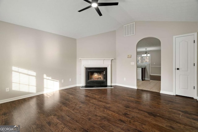 unfurnished living room featuring vaulted ceiling, wood-type flooring, and ceiling fan with notable chandelier