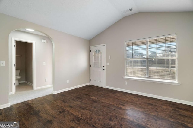 unfurnished room with vaulted ceiling and dark hardwood / wood-style floors