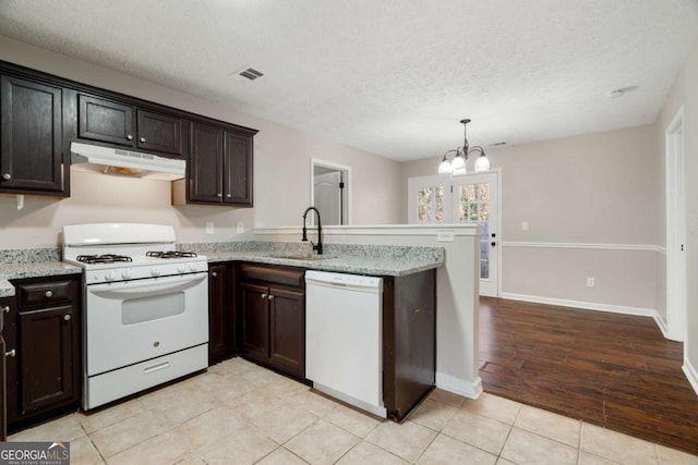 kitchen featuring sink, light stone counters, white appliances, and kitchen peninsula