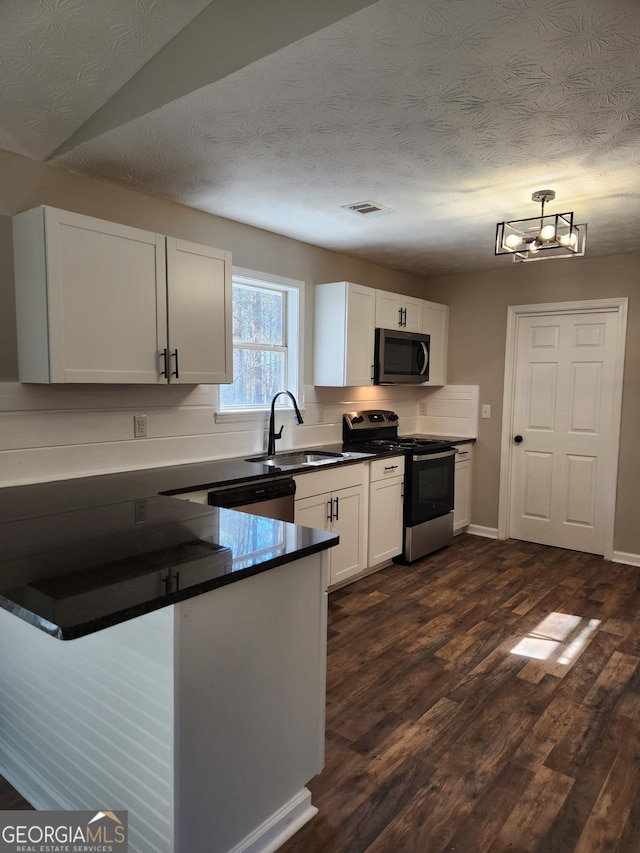 kitchen with sink, dark wood-type flooring, stainless steel appliances, and white cabinets