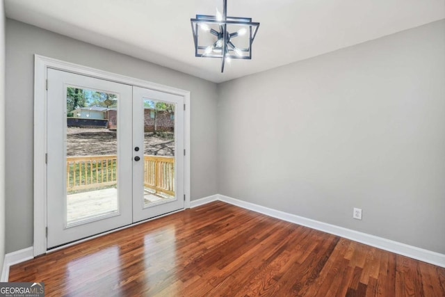 unfurnished dining area with french doors, hardwood / wood-style floors, and a notable chandelier