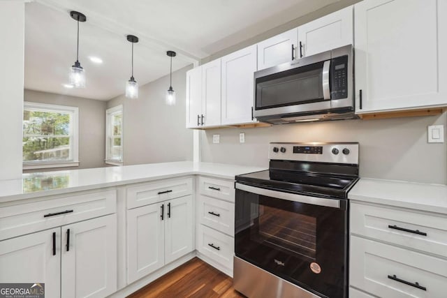 kitchen featuring white cabinetry, stainless steel appliances, decorative light fixtures, and kitchen peninsula