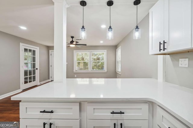 kitchen featuring dark wood-type flooring, ceiling fan, white cabinets, decorative light fixtures, and kitchen peninsula