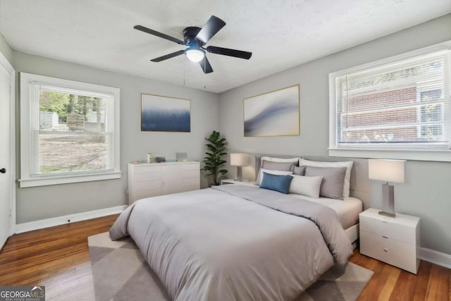 bedroom with a textured ceiling, light hardwood / wood-style floors, and ceiling fan