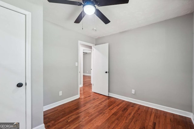 unfurnished bedroom with dark hardwood / wood-style flooring and ceiling fan