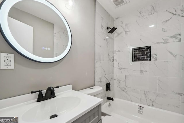 full bathroom featuring tiled shower / bath, vanity, and toilet