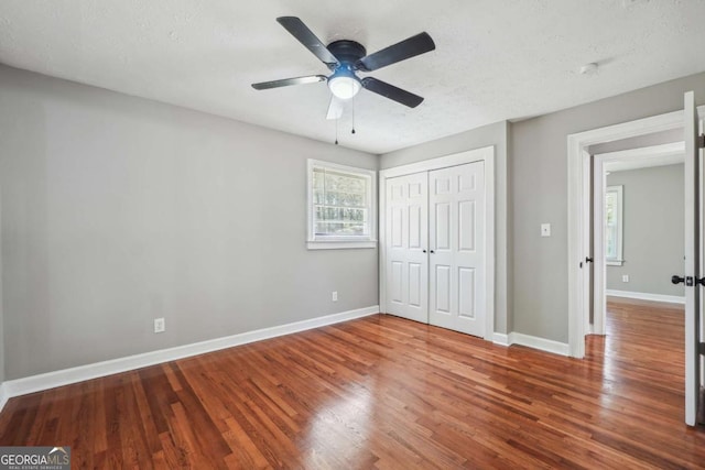 unfurnished bedroom featuring ceiling fan, hardwood / wood-style floors, a closet, and a textured ceiling