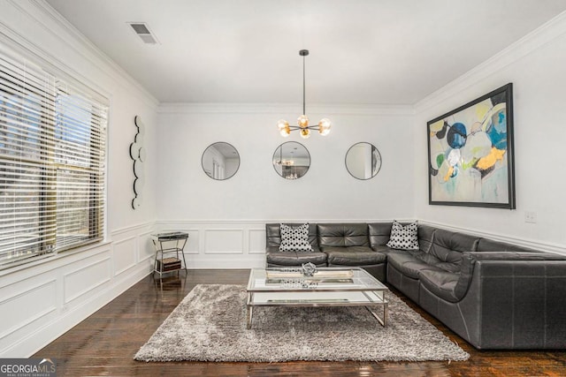 living room with an inviting chandelier, ornamental molding, and dark hardwood / wood-style floors