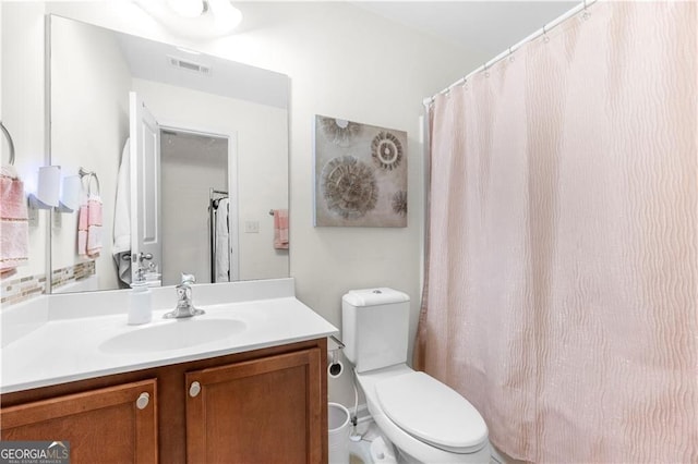 bathroom with vanity, curtained shower, and toilet