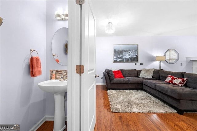 living room with hardwood / wood-style floors and sink