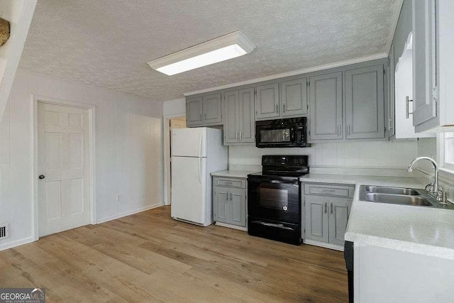 kitchen featuring sink, gray cabinets, black appliances, light hardwood / wood-style floors, and a textured ceiling