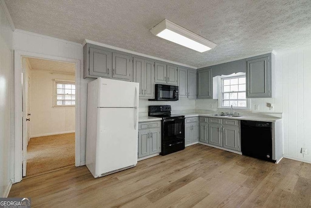 kitchen with gray cabinets, sink, light hardwood / wood-style floors, and black appliances