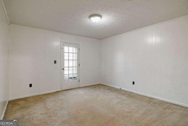 carpeted empty room featuring a textured ceiling