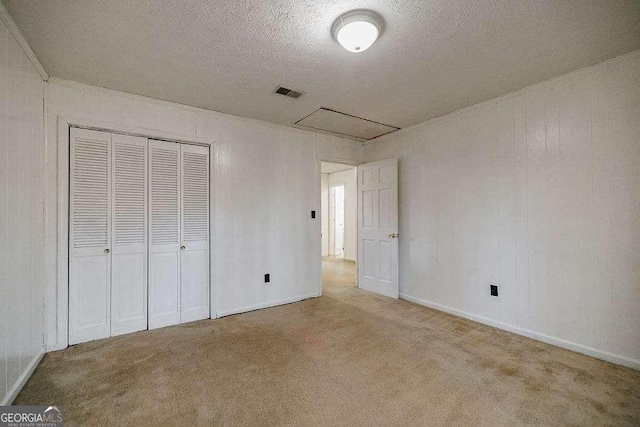 unfurnished bedroom with carpet flooring, a closet, and a textured ceiling