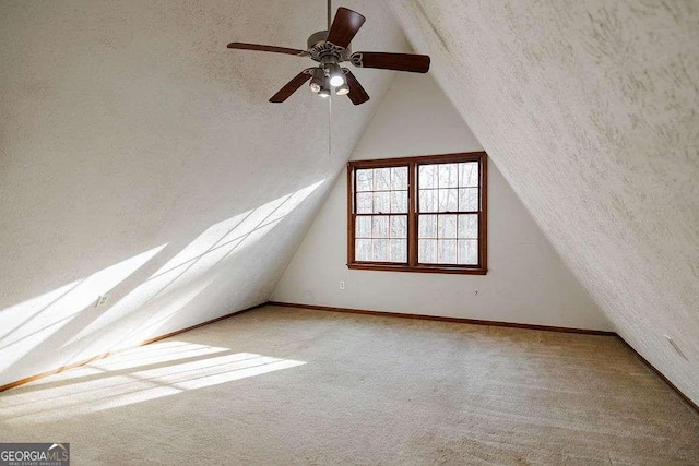 additional living space with vaulted ceiling, carpet flooring, and a textured ceiling