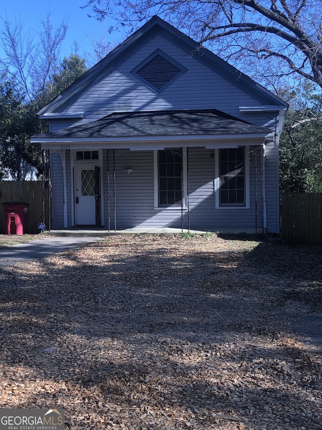 view of front facade featuring covered porch and fence