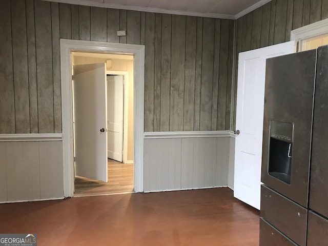 empty room featuring wood walls and ornamental molding