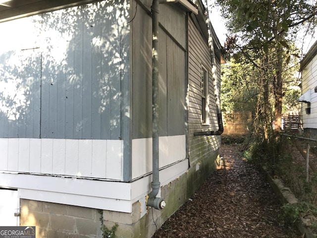 view of side of home featuring fence