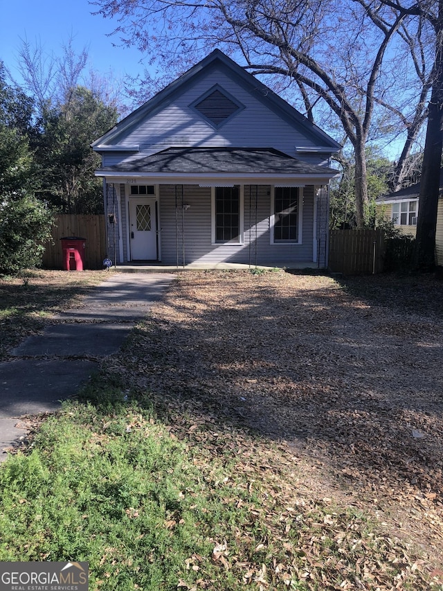 view of front of home featuring covered porch and fence