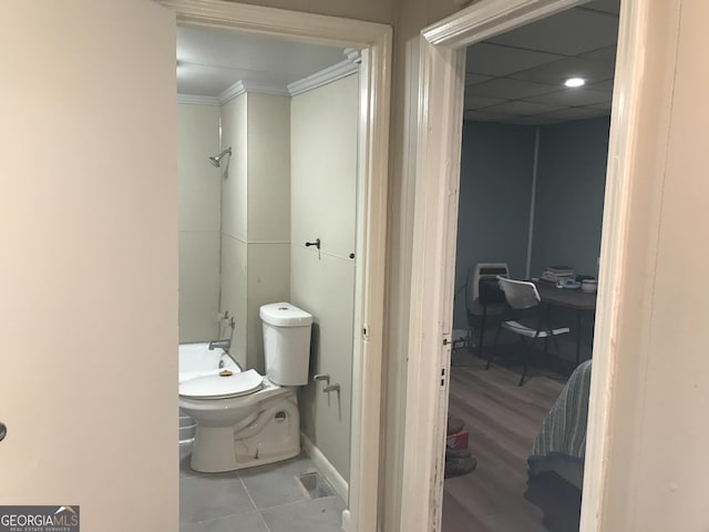 full bathroom with baseboards, a drop ceiling, toilet, and tile patterned floors