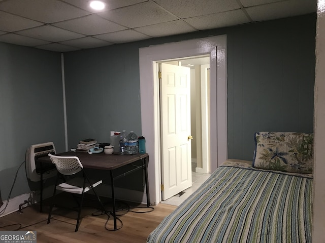 bedroom featuring a paneled ceiling and light hardwood / wood-style flooring