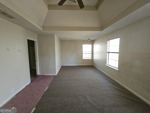 carpeted empty room featuring a tray ceiling and ceiling fan