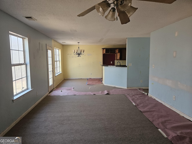 spare room featuring sink, ceiling fan with notable chandelier, a textured ceiling, and carpet flooring