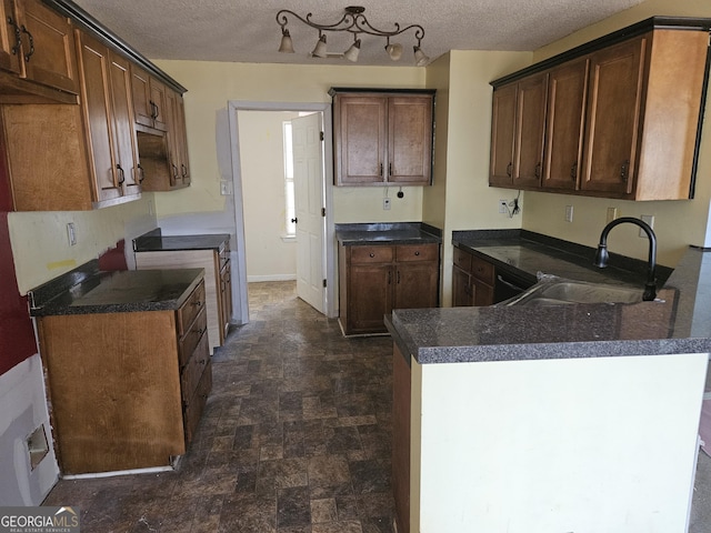 kitchen with stove, sink, black dishwasher, and a textured ceiling