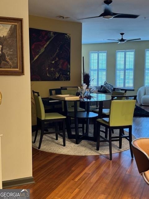 dining space featuring wood-type flooring and ceiling fan