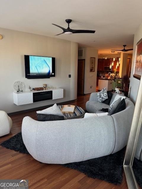 living room featuring hardwood / wood-style floors and ceiling fan