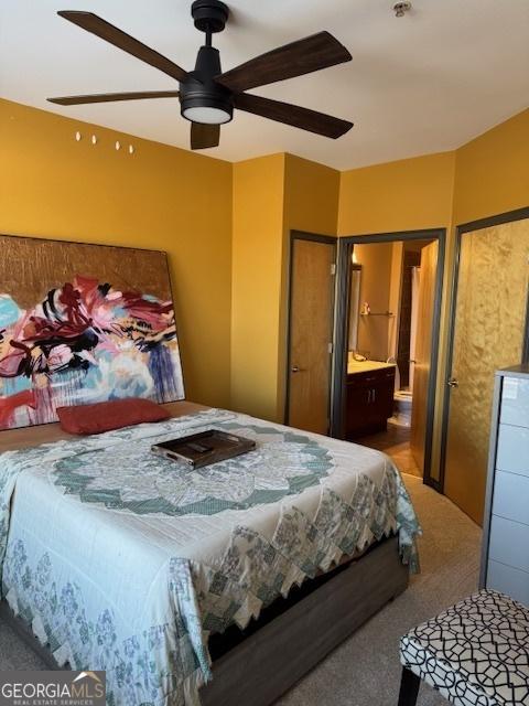 carpeted bedroom featuring ceiling fan and connected bathroom