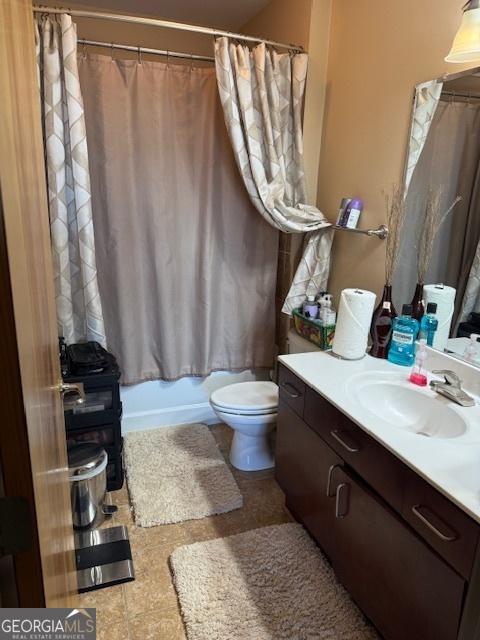 full bathroom featuring shower / tub combo with curtain, vanity, and toilet