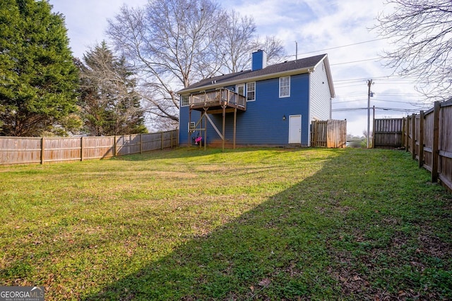 back of property featuring a yard, a fenced backyard, and a chimney