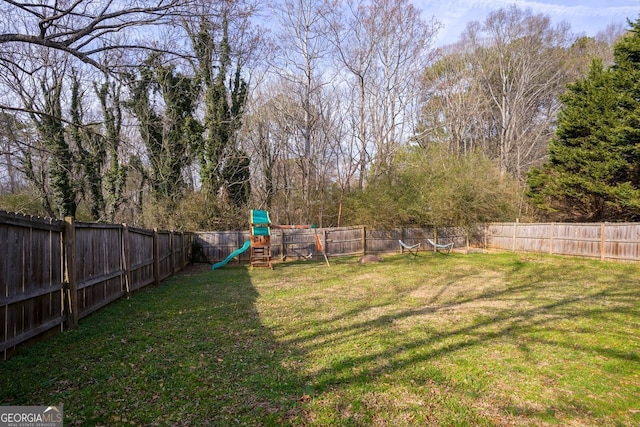 view of yard featuring a playground and a fenced backyard